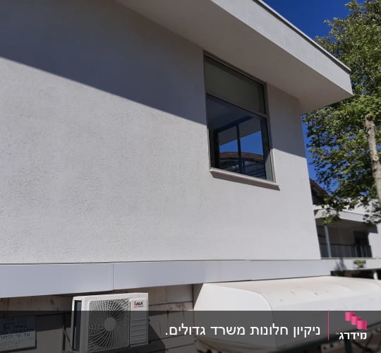 קיר חיצוני עם מזגן, חלון פתוח ועץ קרוב